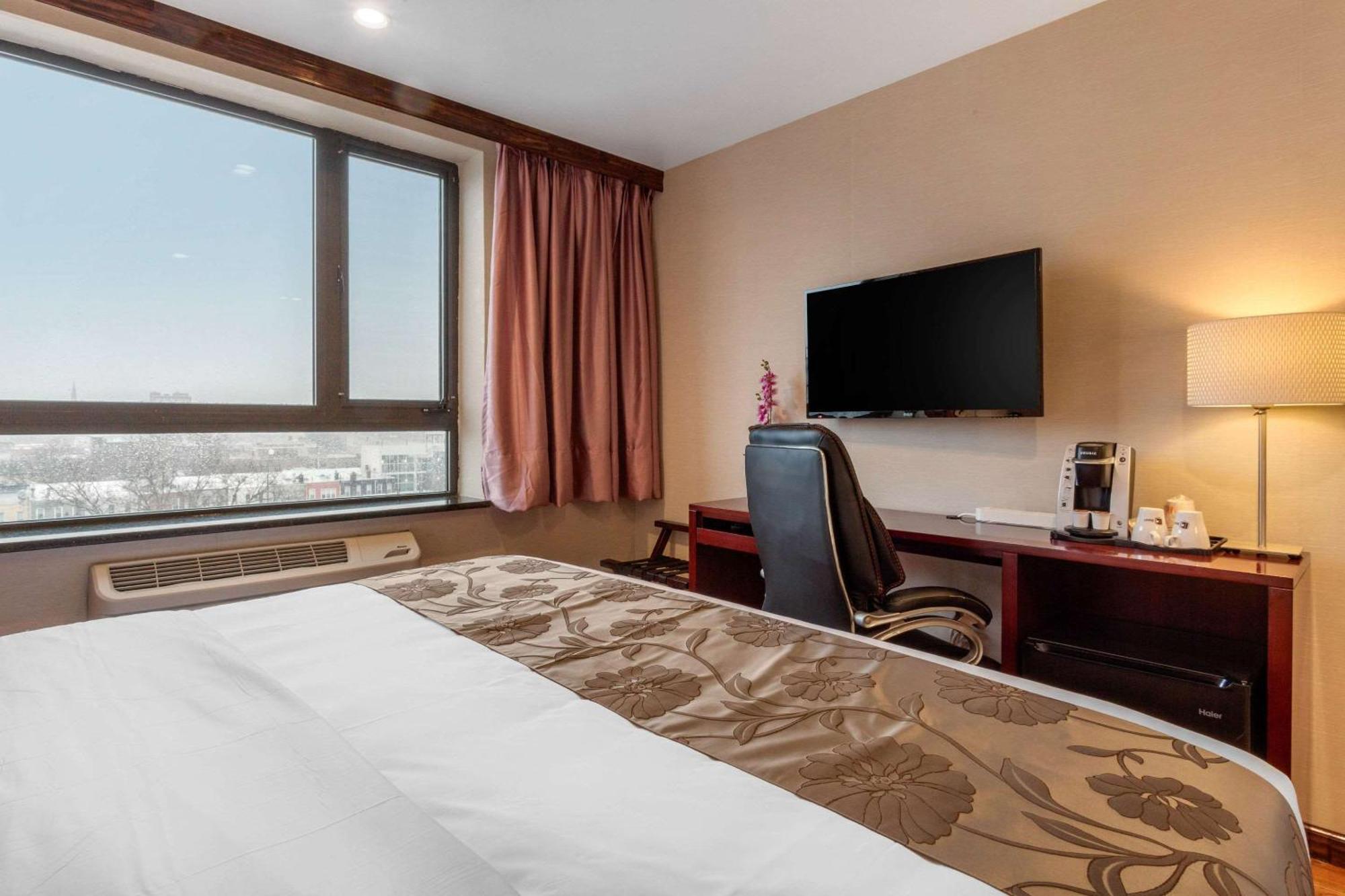 Nichtraucher Suite mit Kingsize-Bett und Blick auf die Stadt.