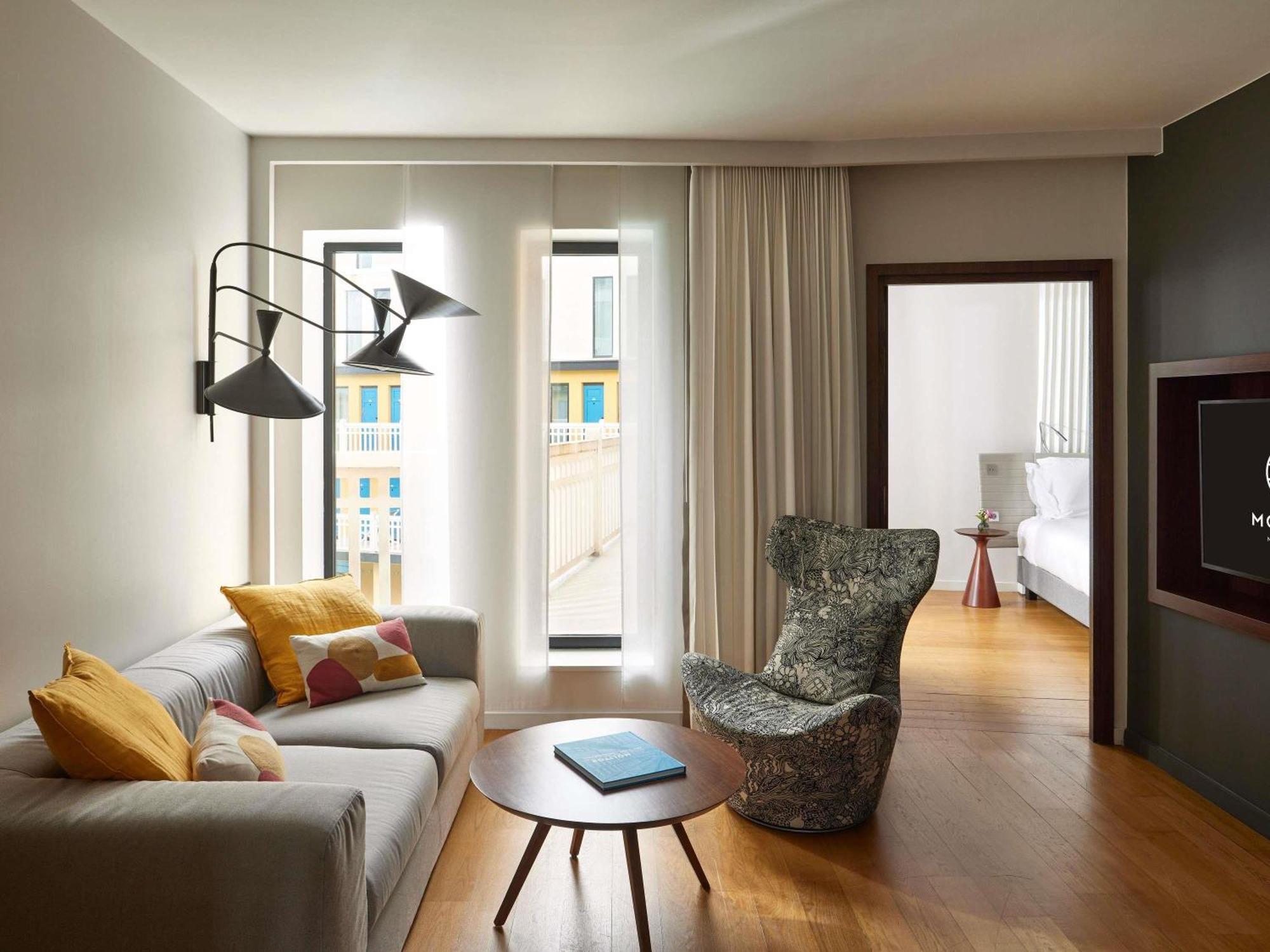 Suite mit Kingsize-Bett, Schlafsofa, Wohnbereich und Poolblick